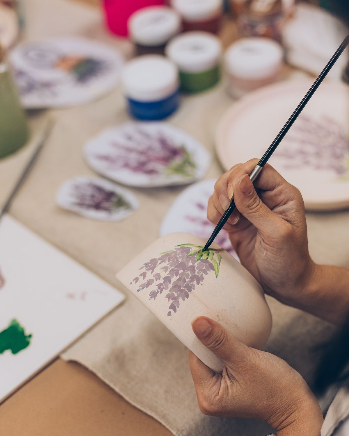 Manos con un pincel pintando un bowl de cerámica